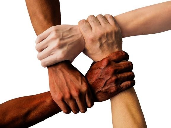 4 hands of people of different color making a not